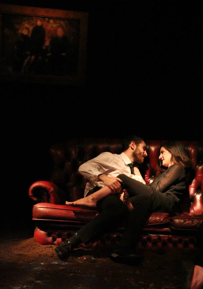 Photo of two characters cuddling on a sofa in the play Victory. 